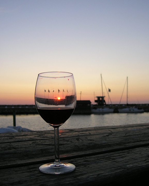 Toma un buen vino en una puesta de sol junto al mar